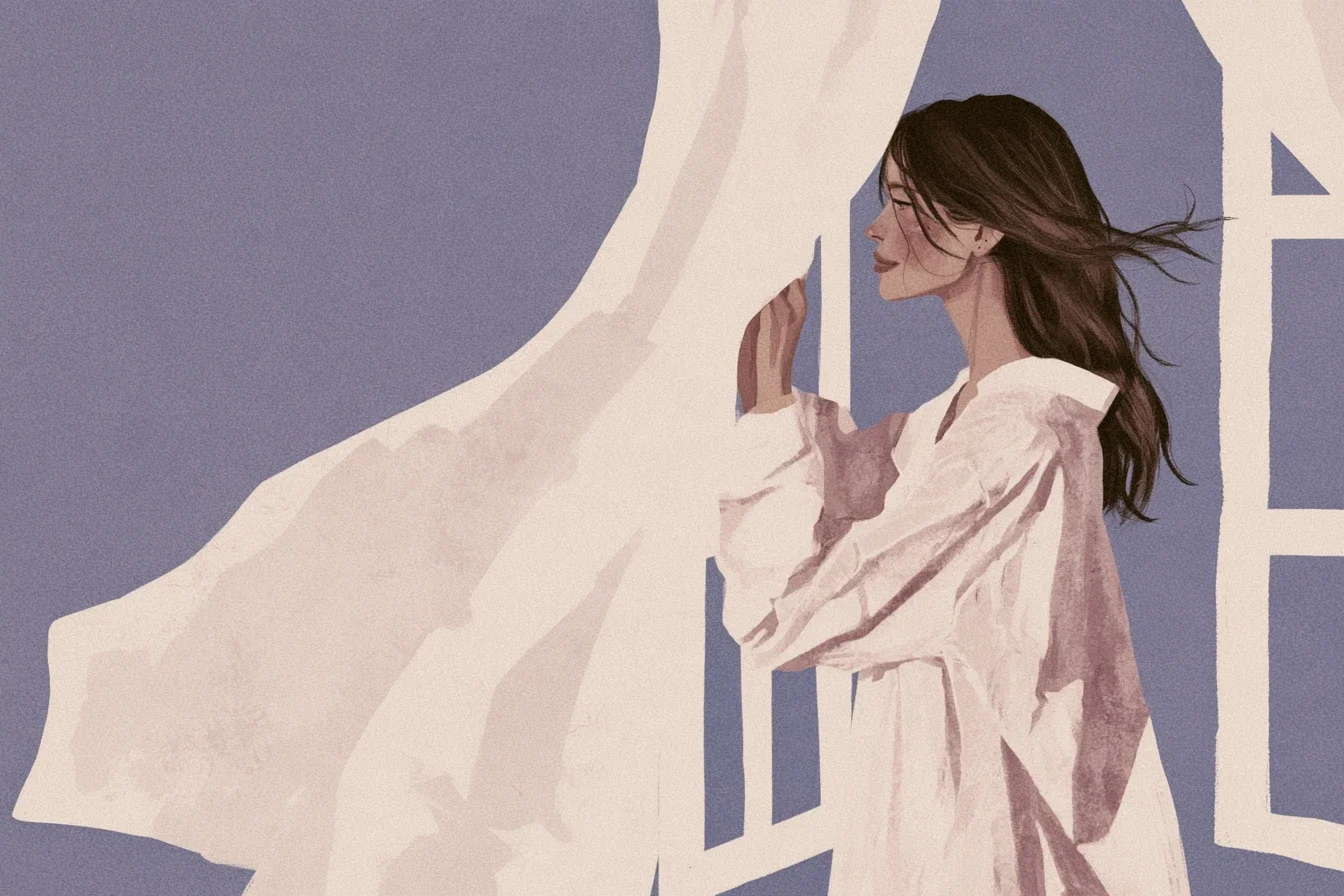 Mujer de perfil con una camisa blanca larga que abre una cortina movida por el viento frente a una ventana