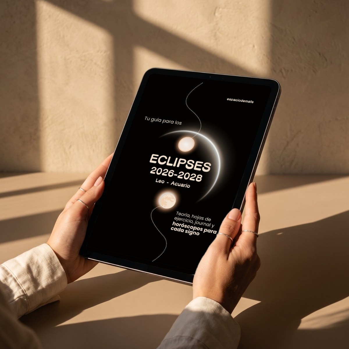 La portada del e-book de eclipses en una tableta sostenida con las dos manos